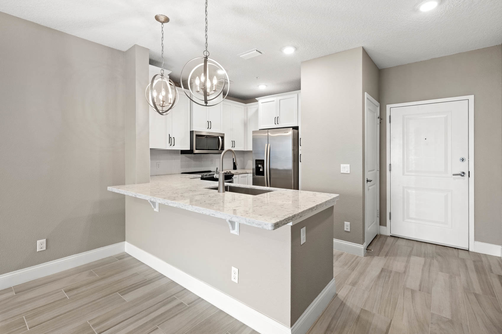 inside front entrance with kitchen and wood plank floors